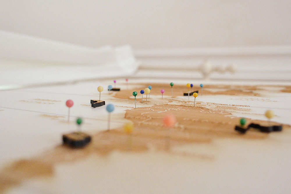 Um mapa sobre uma mesa com diversos alfinetes marcando diferentes regiões, demonstrando a possibilidade de Atendimento jurídico em diversas cidades com a ADVBOX