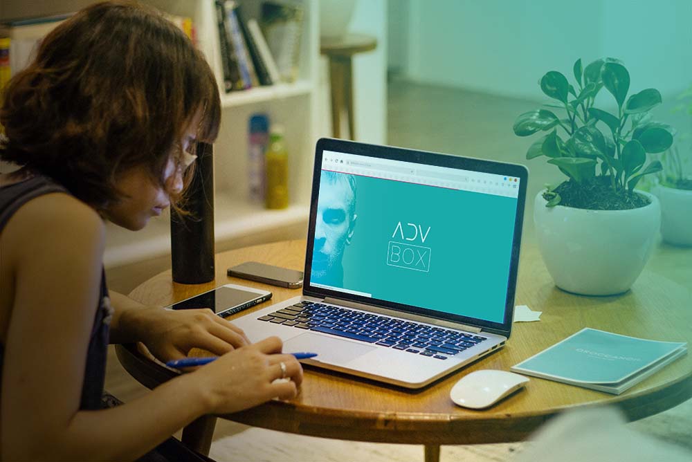 Advogada operando o sistema ADVBOX em um notebook sobre uma mesa, representando um sistema de gestão de escritórios de advocacia
