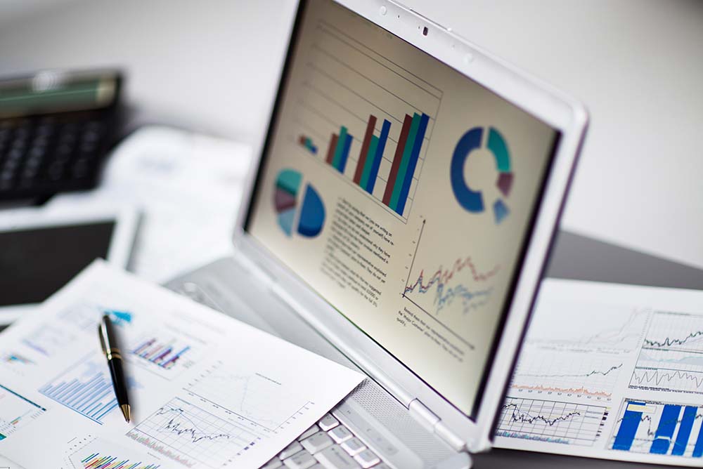 Notebook aberto, onde na tela aparecem diversos gráficos, representando os meios de medir o Crescimento do Escritório